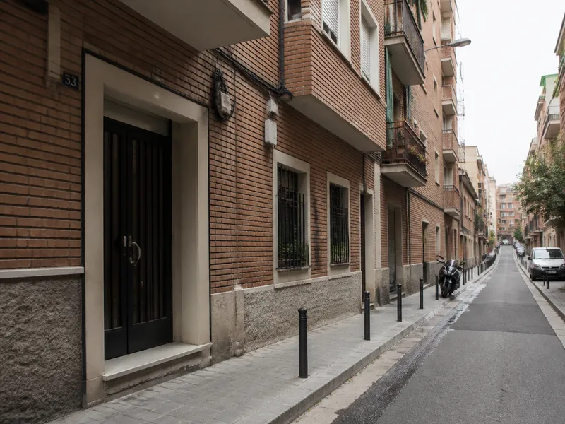 Calle residencial de L’Hospitalet de Llobregat con bloques y portales de viviendas