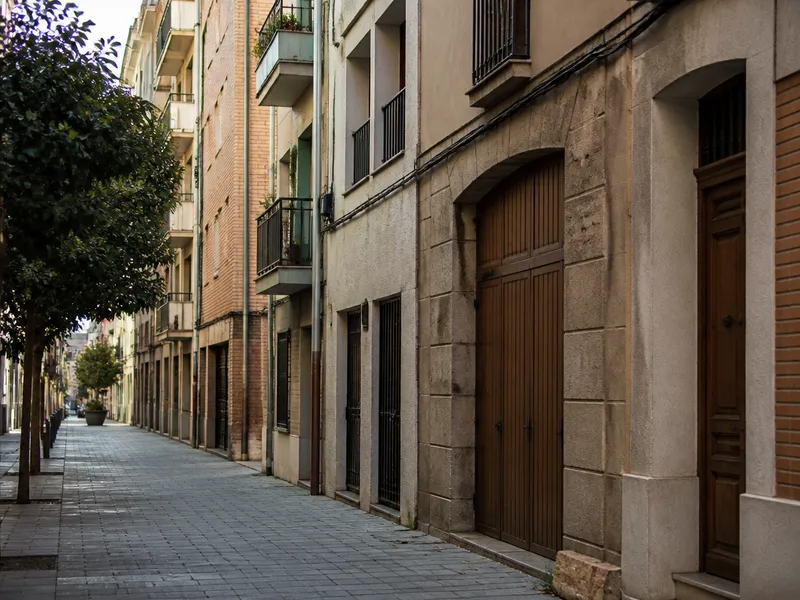 Calle de una ciudad del Vallès con bloques y puertas de madera, típica zona de aviso