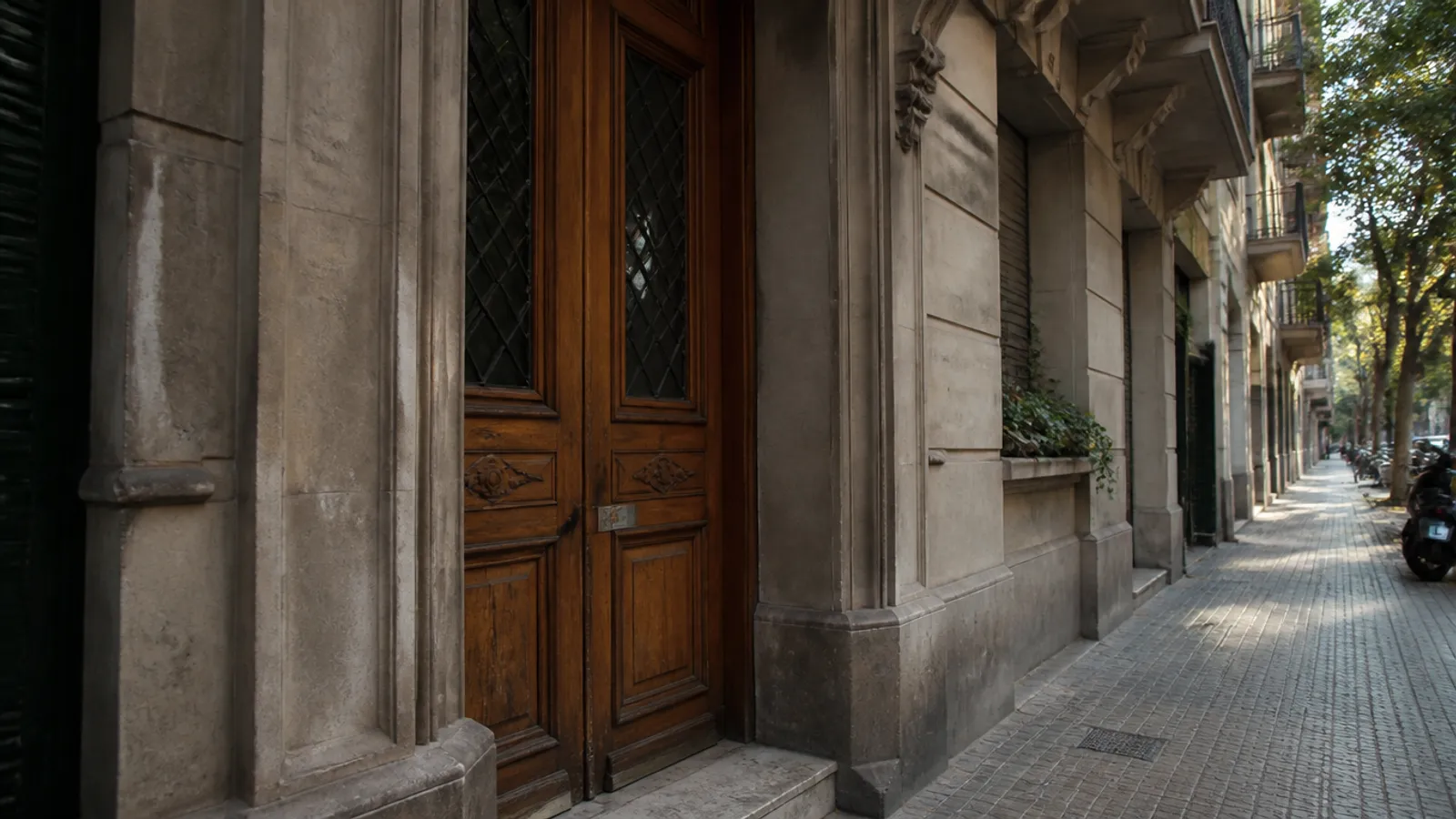 Portal d’un pis de l’Eixample de Barcelona amb pany a la porta de fusta, servei de serraller a domicili