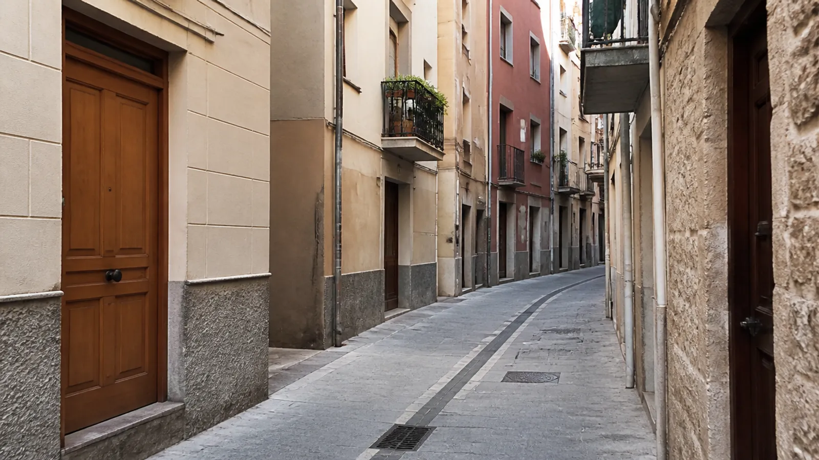 Carrer del casc de Sant Feliu de Llobregat amb edificis modestos i portals d’habitatge