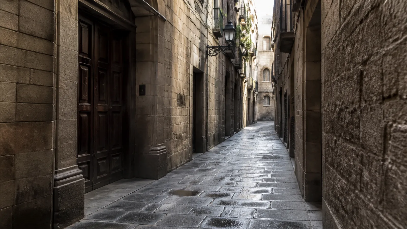 Calle estrecha del Barri Gòtic de Barcelona con muros de piedra, portales de madera y adoquines