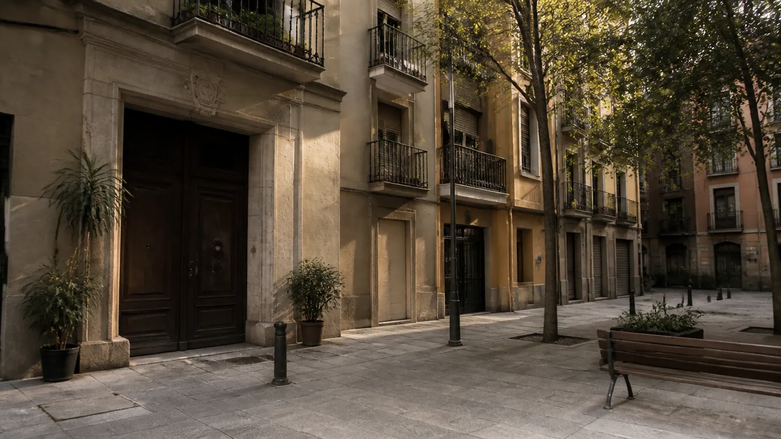 Calle residencial del barrio de Gràcia en Barcelona con fachadas de estuco, balcones y portales de finca