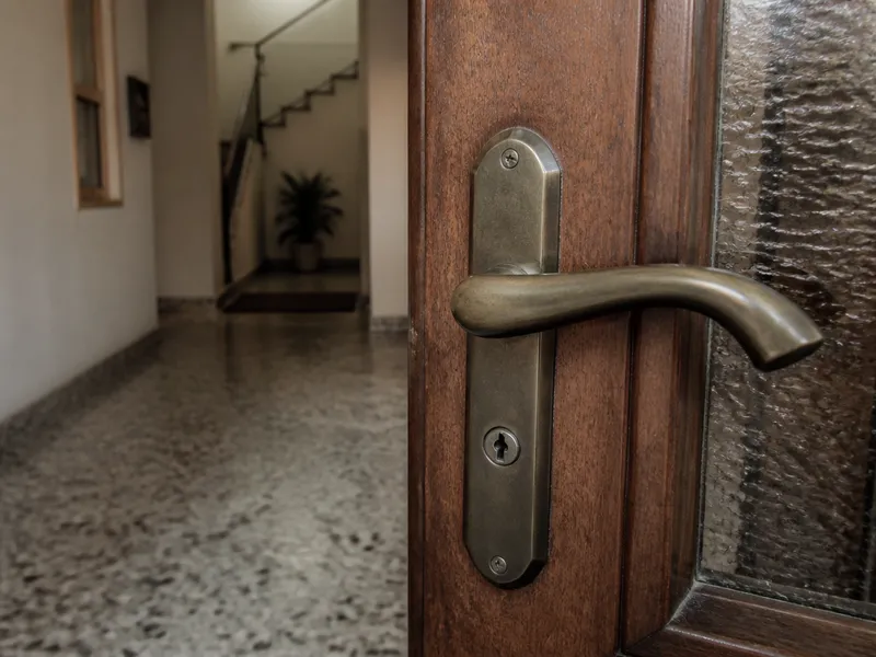 Community portal door in Sant Boi, handle and lock in close-up