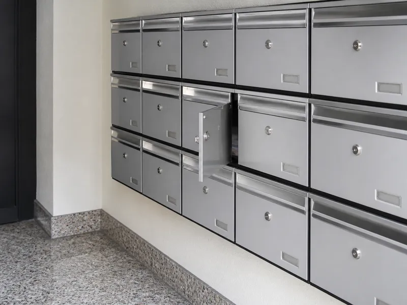 Banc de bústies d’un vestíbul de Santa Coloma amb portes de caseller entreobertes